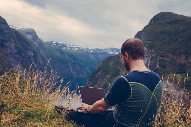 it guy on mountain with laptop 